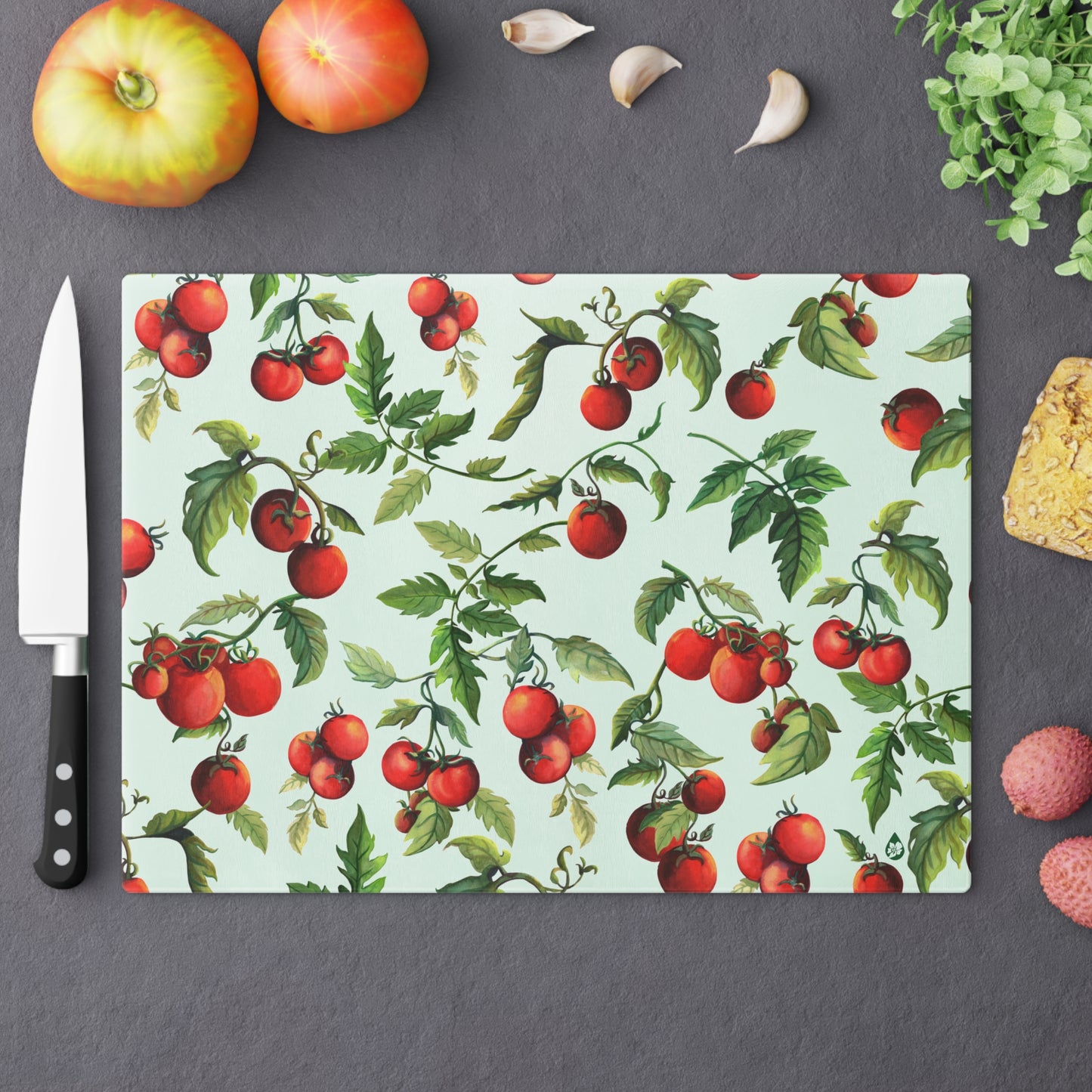 Large Tomato Tomato tempered glass cutting board on counter with fruit and chefs knife