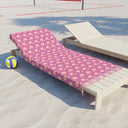 Side View of Watercolor Woodblock Beach Towel with Tassels on a beach lying across beach lounger by volleyball net in Peony Pink Color Option