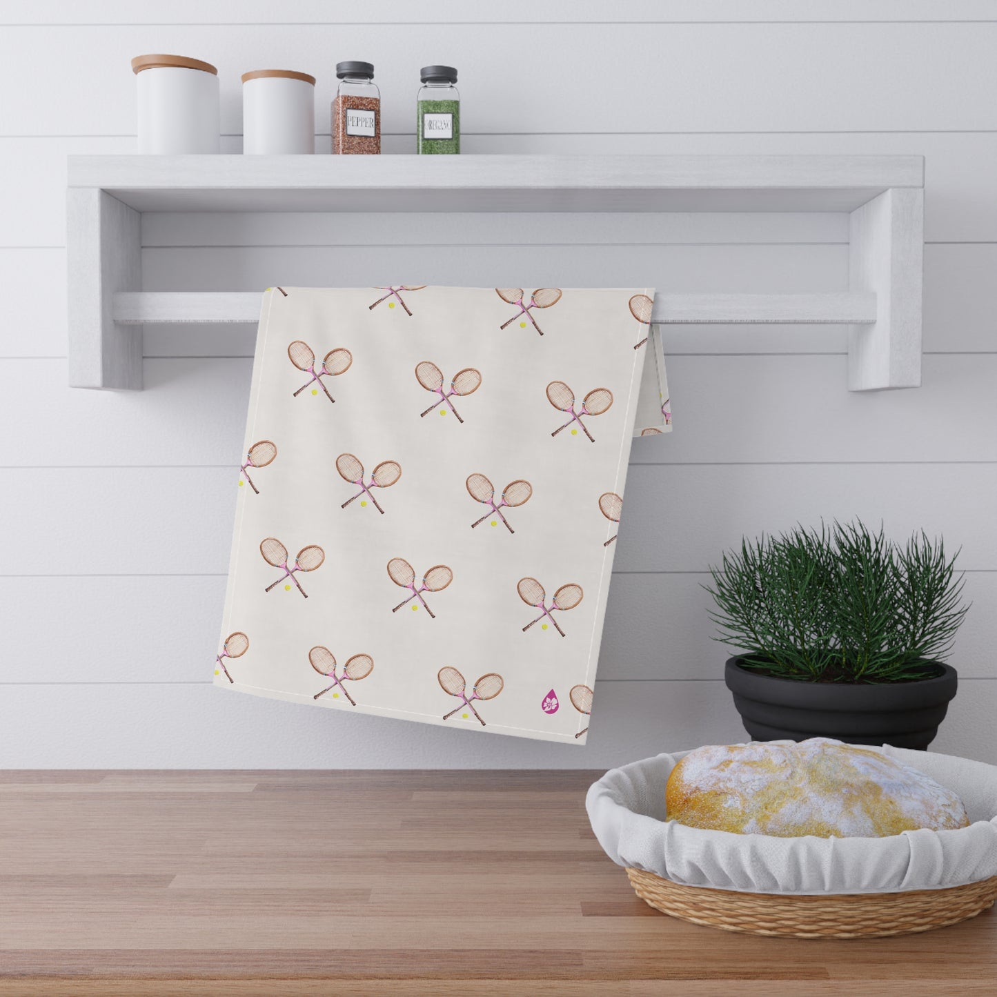 Grass courts kitchen towel on towel rack over kitchen counter in Peony Pink Racquets
