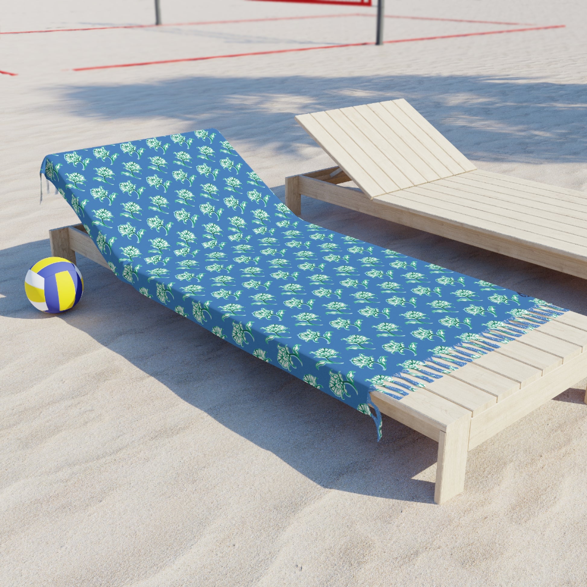 Side View of Watercolor Woodblock Beach Towel with Tassels on a beach lying across beach lounger by volleyball net in Cloudless Blue Color Option