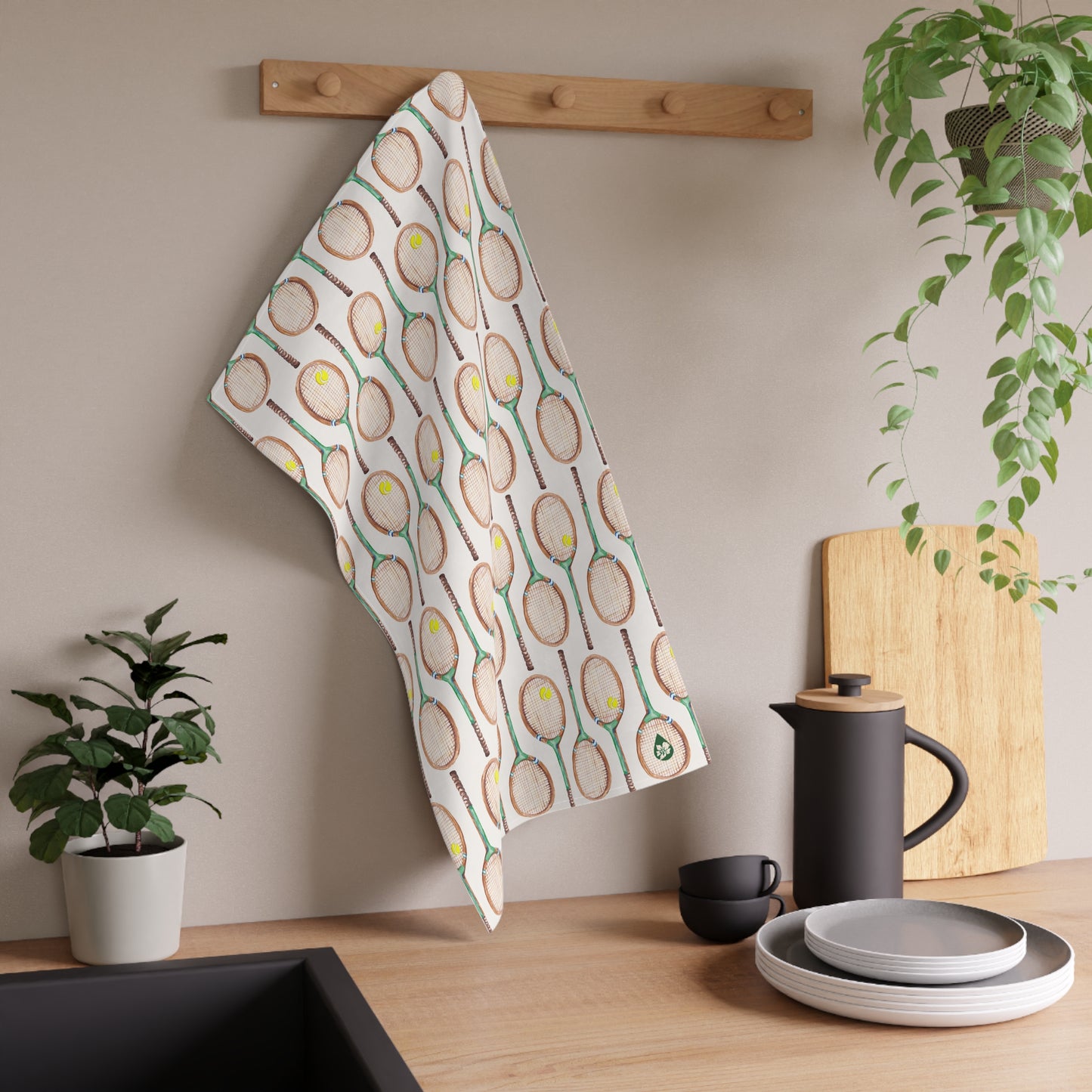 Topspin Tennis print kitchen towel in green hanging on hook over kitchen counter