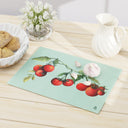 Flat view of Large Jersey Fresh Tomato tempered glass cutting board on table with pitcher vase of flowers and basket of bread