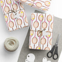 Topspin Tennis Wrapping Paper on table with wrapping tape, string, and scissors and wrapped gifts in Peony Pink Color Choice