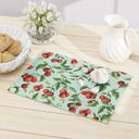 Tomato Tomato tempered glass cutting board on table with white pitcher vase of flowers and basket of bread