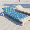 Side View of Watercolor Woodblock Beach Towel with Tassels on a beach lying across beach lounger by volleyball net in Cloudless Blue Color Option
