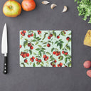 Small Tomato Tomato tempered glass cutting board on counter with fruit and chefs knife