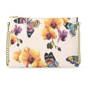 A rectangular clutch bag with a light cream textured background, decorated with a vibrant pattern of yellow-orange orchids and colorful butterflies. The bag features gold-tone hardware, including a top zipper, side rings, and a gold chain strap.