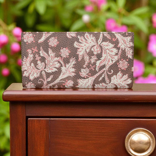 Floral-patterned wallet on a wooden surface with blurred pink flowers in the background