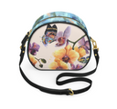 A small oval crossbody bag with a colorful floral and butterfly print on a light beige background, featuring a black leather strap and gold-tone hardware, shown on a plain white background.