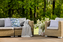 Hydrangea Patterned Outdoor Pillows and Prep Stripe Outdoor Pillows on wicker patio furniture on deck outside near woodland property in Cloudless Colorways
