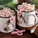 Two white enamel camp cups with a Snow Dog illustration, filled with marshmallows and candy canes on a wooden surface with pine branches in the background.